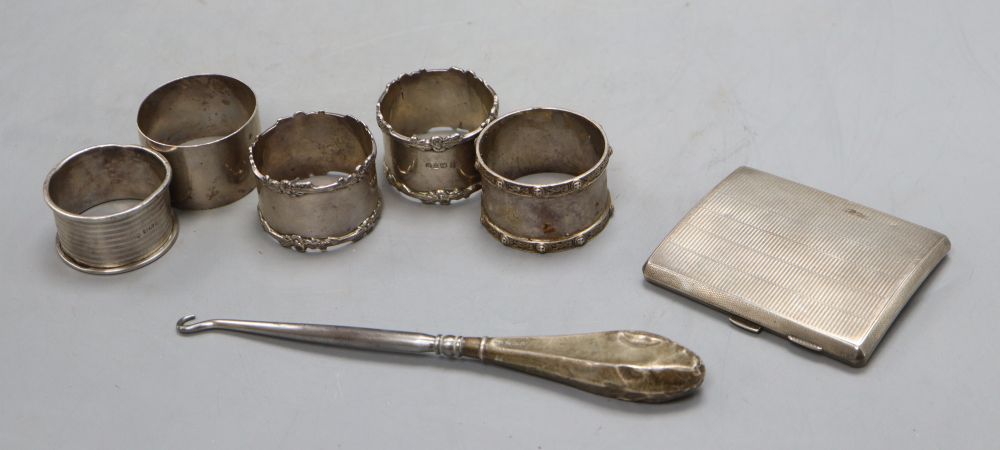 Five assorted silver napkin rings including a pair, a silver cigarette case and button hook, 7oz.